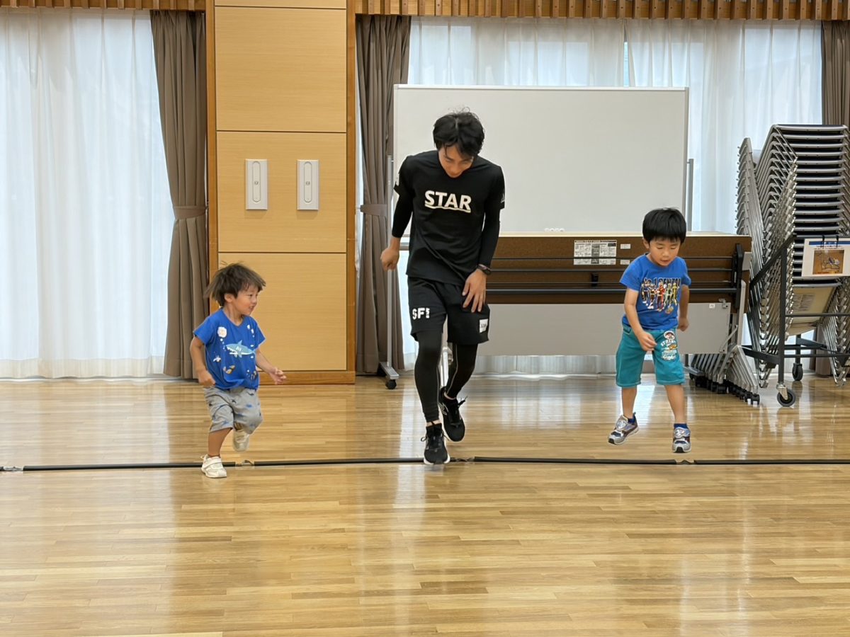 ラインを使ってジャンプする子どもたちと先生