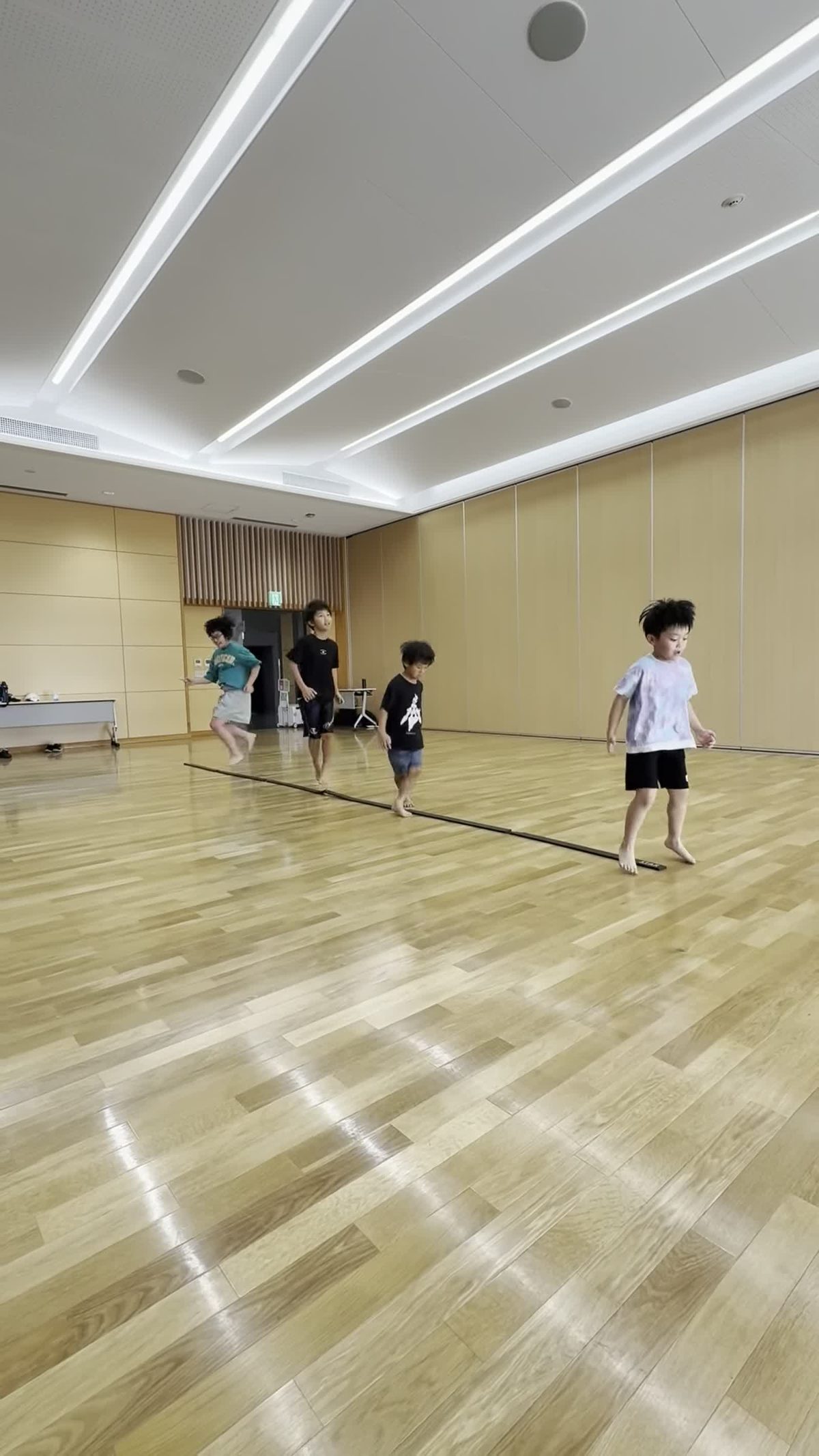 ラインの上で大きくジャンプする年中・年長の子どもたち